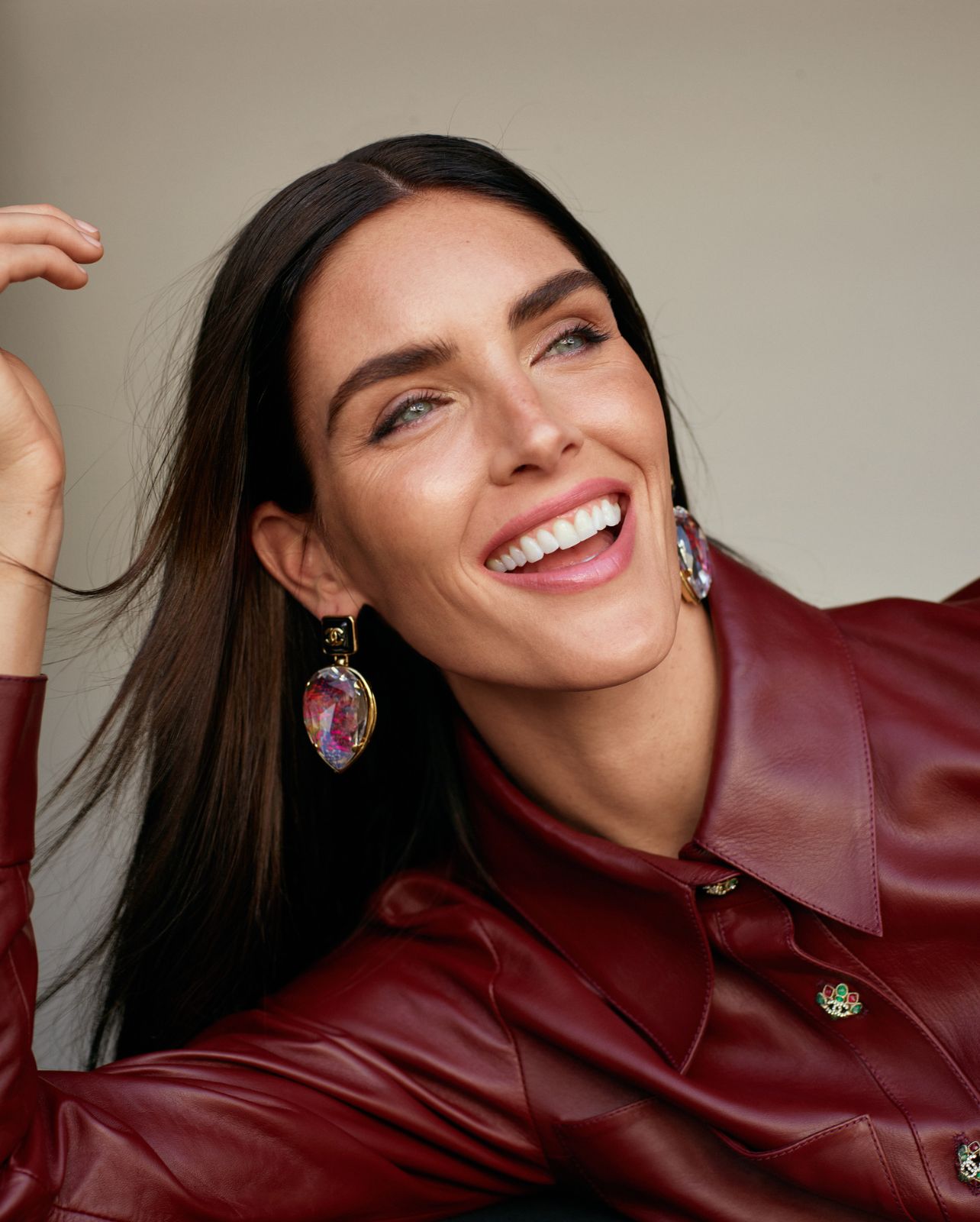 Model smiles in a burgundy leather jacket