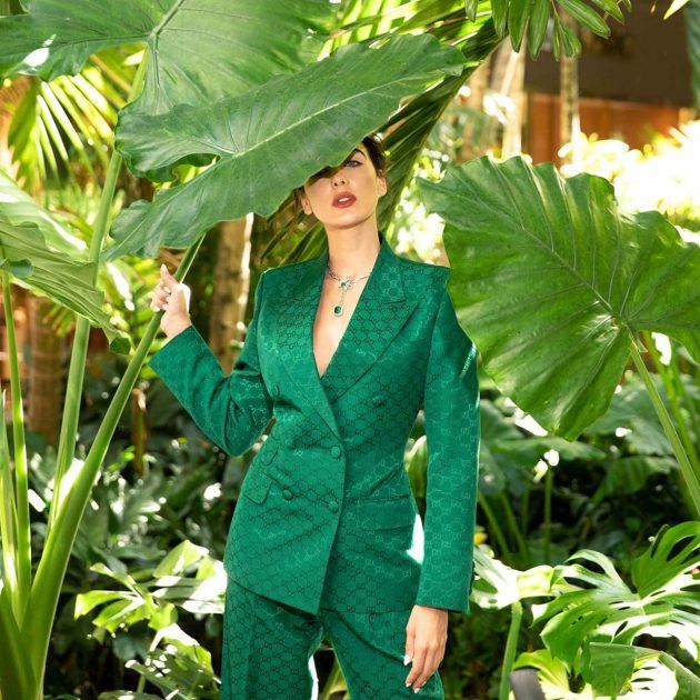 Model in an emerald Gucci suit with signature monogram and a Graff emerald and diamond necklace