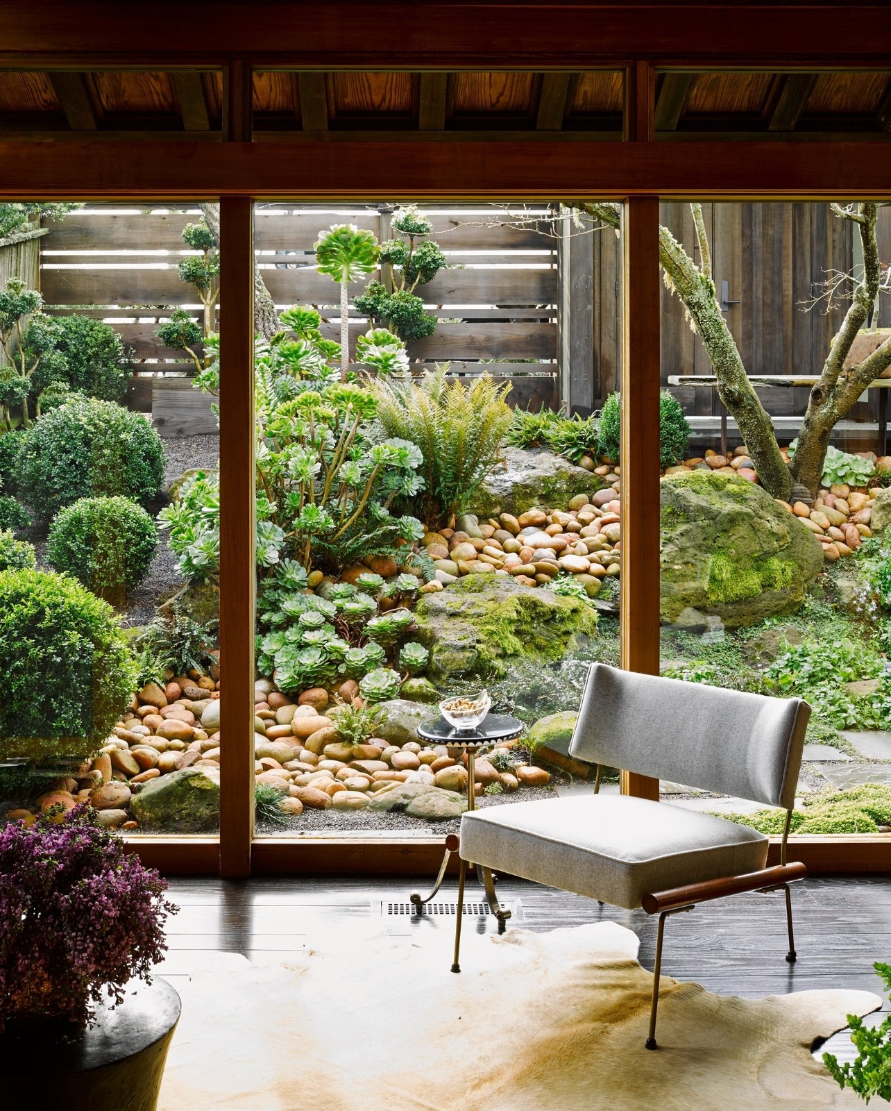 The interior of a room inside Ken Fulks home with a large window overlooking greenery