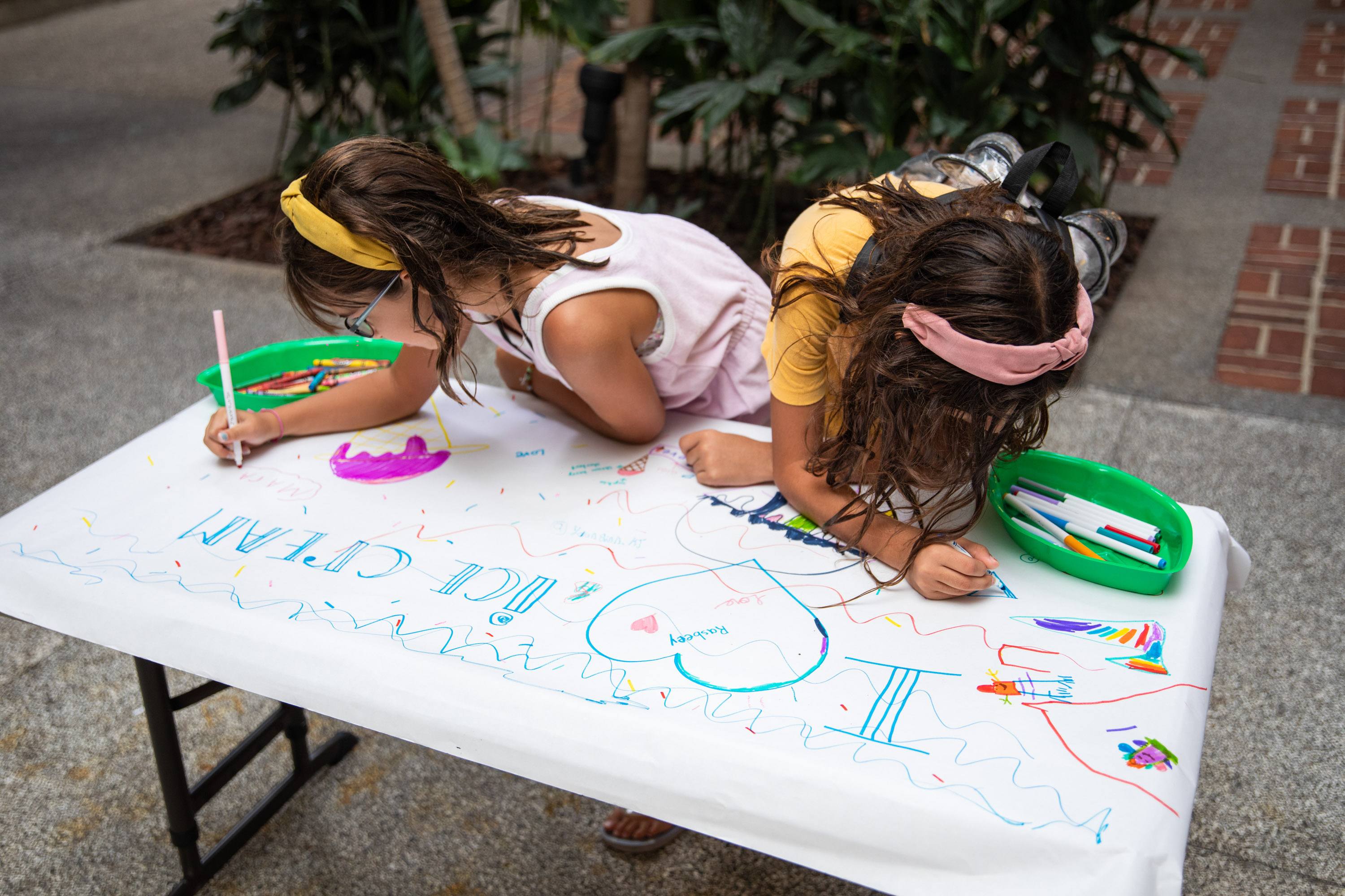 A variety of images showcasing the fourth annual “Ice Cream We Love” event. Images include guests in attendance, ice cream treats and setup, and activities featured at the event including games, face painting, and performances.