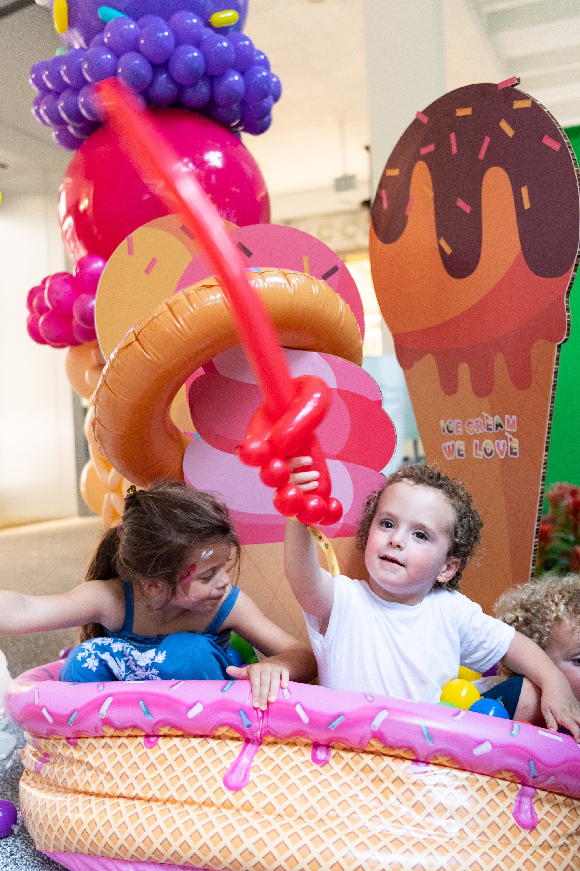 A variety of images showcasing the fourth annual “Ice Cream We Love” event. Images include guests in attendance, ice cream treats and setup, and activities featured at the event including games, face painting, and performances.