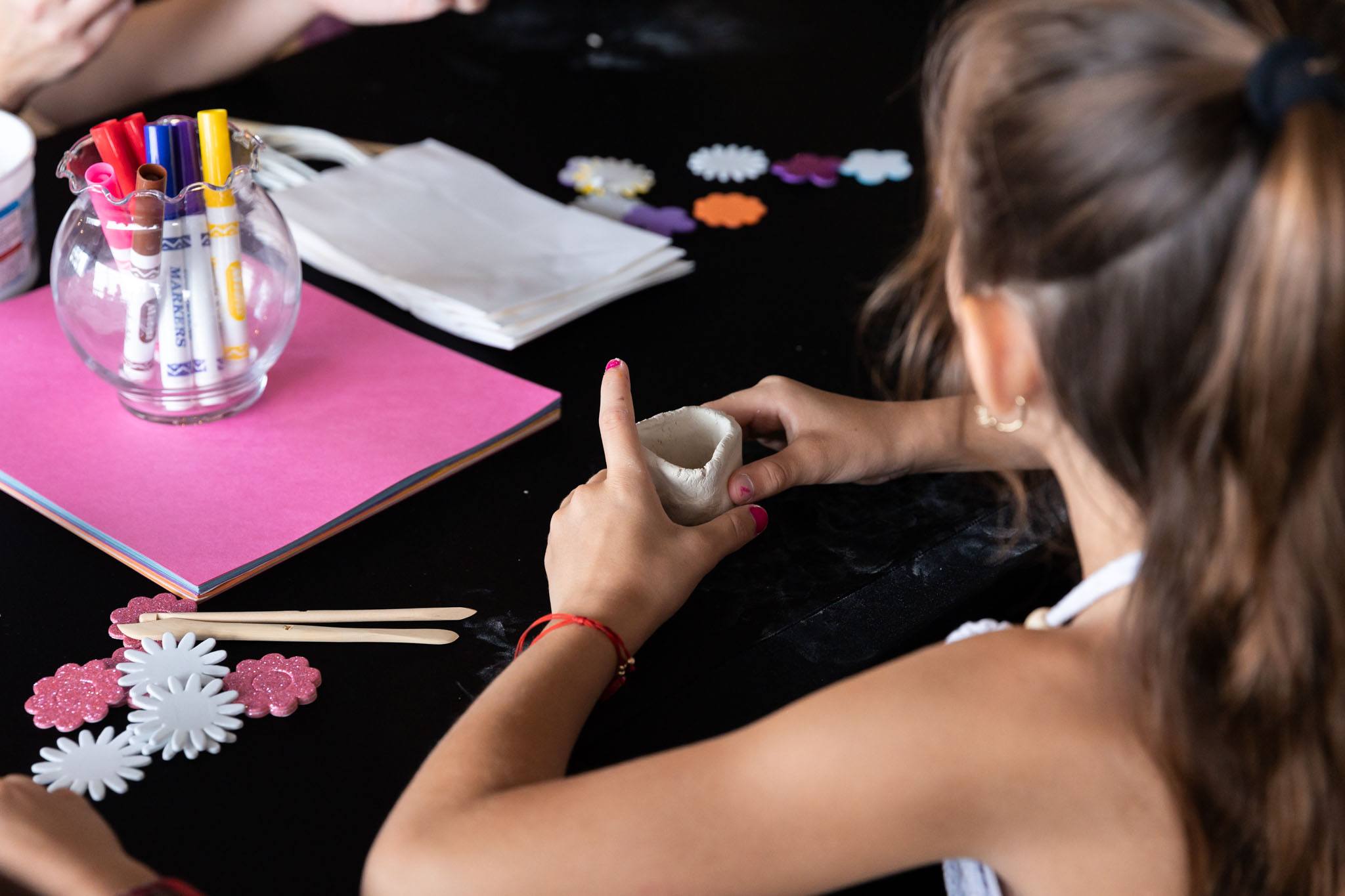 Child in attendance creating a clay floral vase