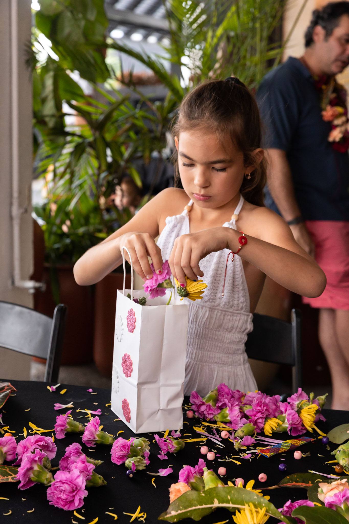 Child putting her floral creations into her custom gift bag