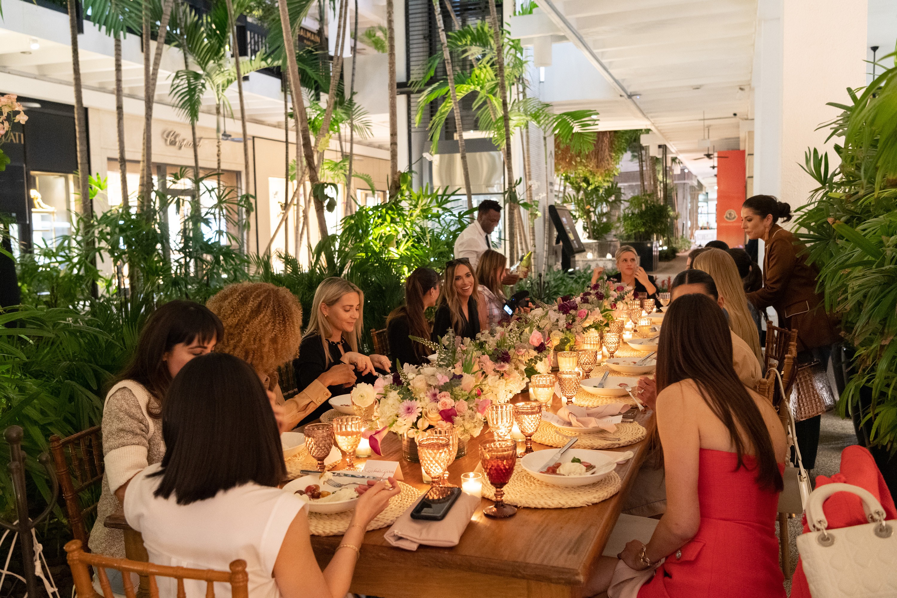 Guests gathered around a beautifully adorned tablescape inspired by Veronica Beard’s SS ‘23 collection