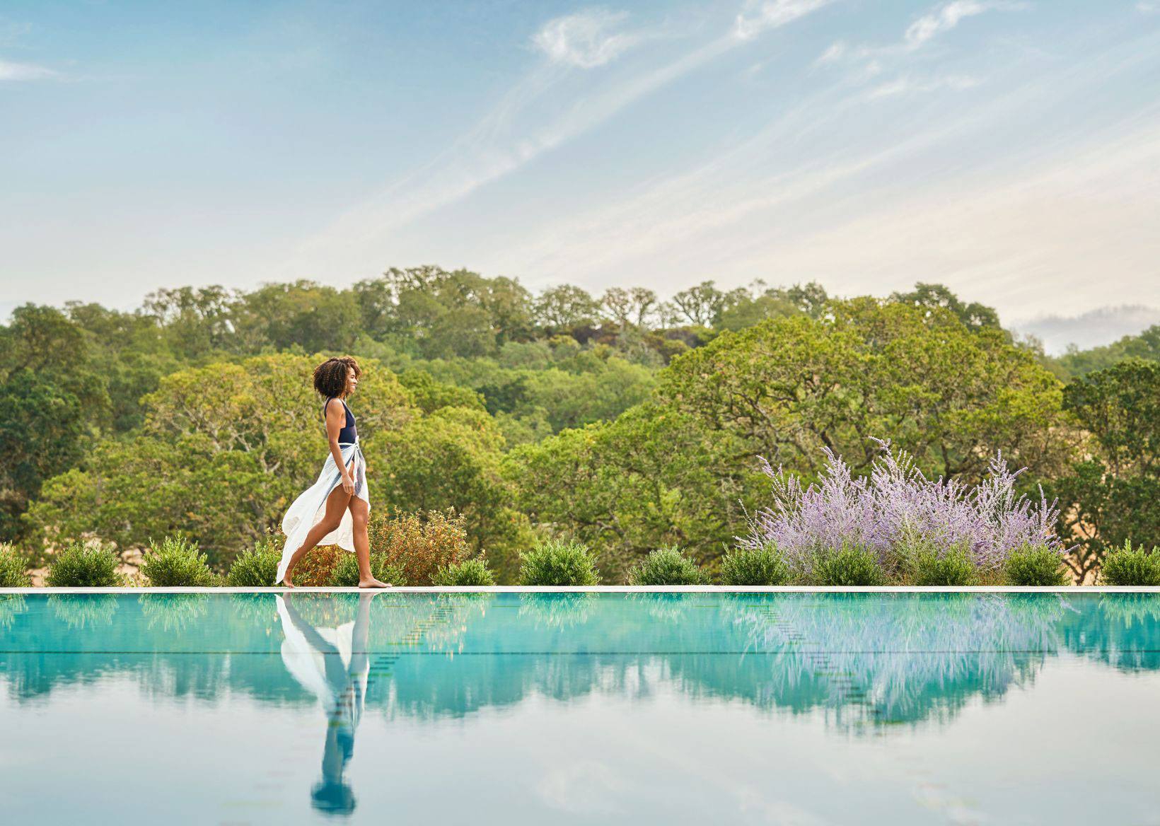 Woman walking along the infinity pool at the Montage Healdsburg in Healdsburg California