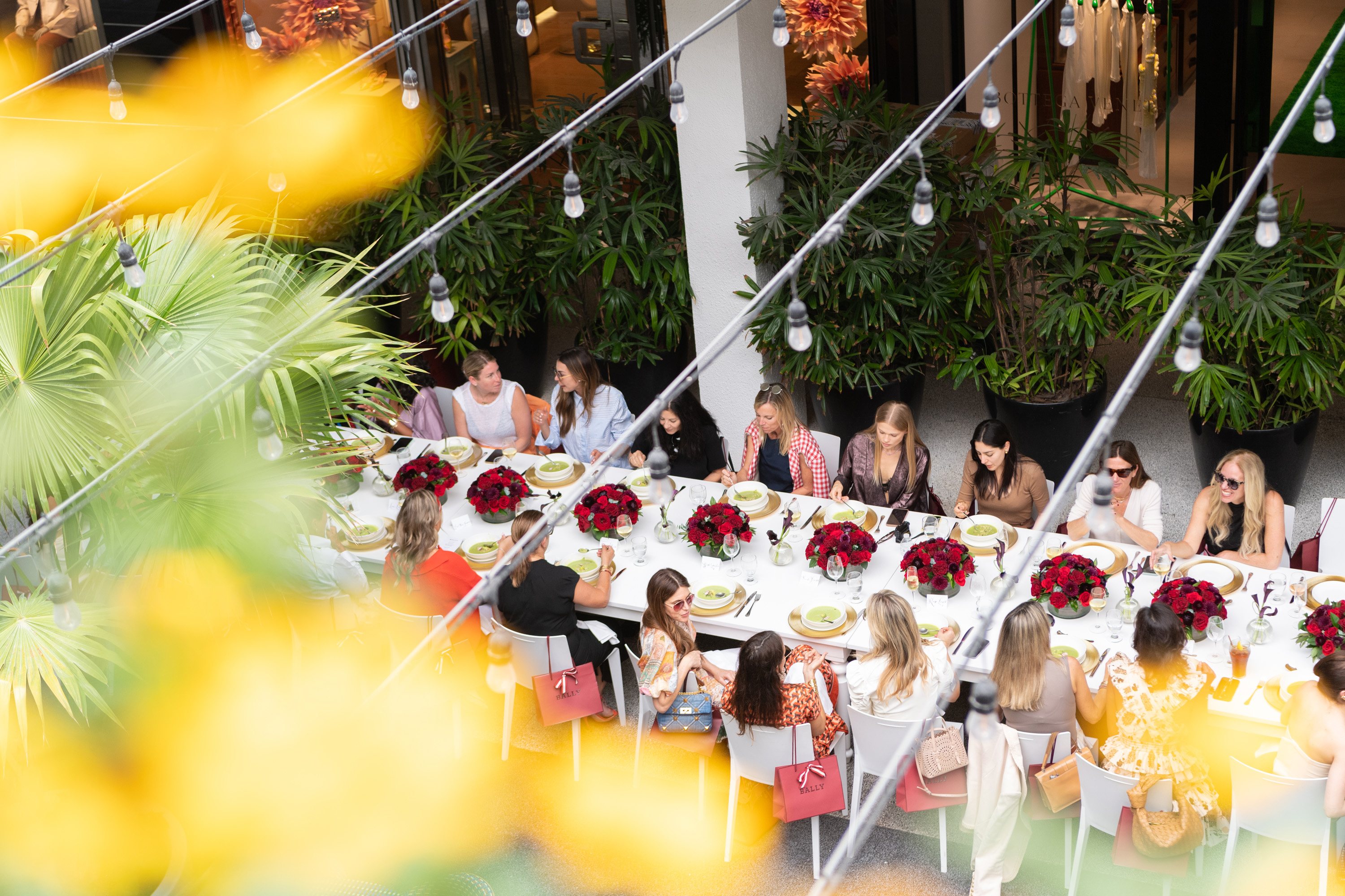Guests gathered around a beautifully adorned tablescape inspired by Ballys SS ‘23 collection