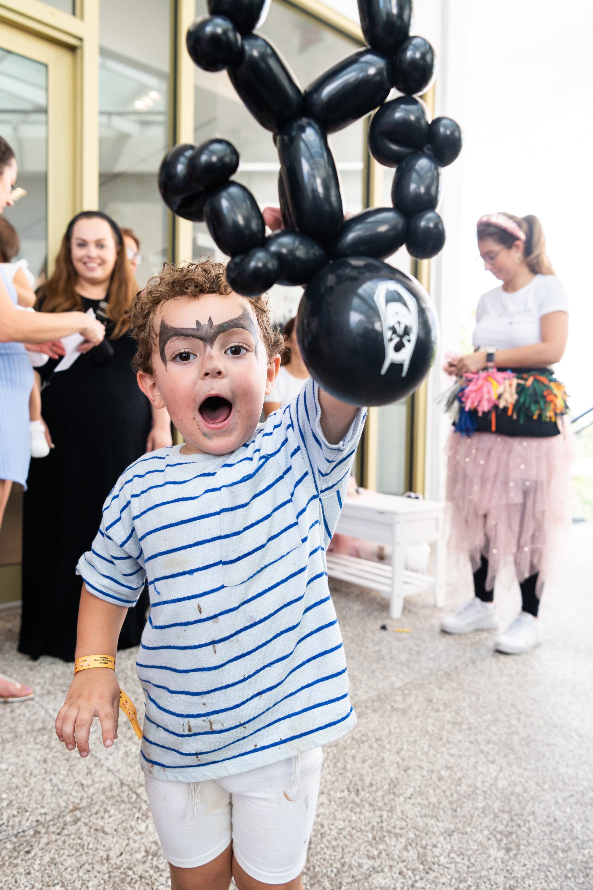 Boy shows off his balloon art and facepaint