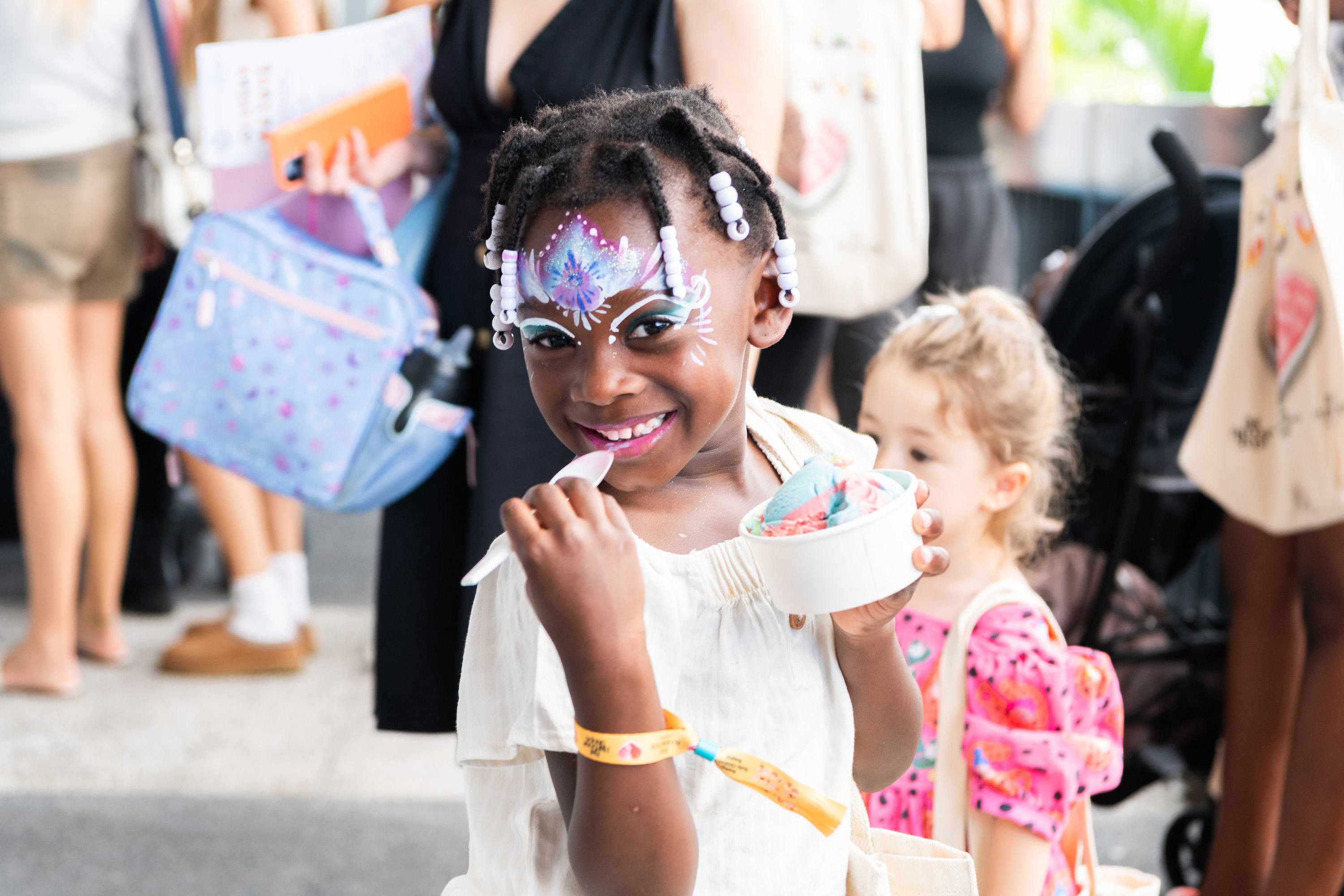 Child enjoying ice cream and custom face paint