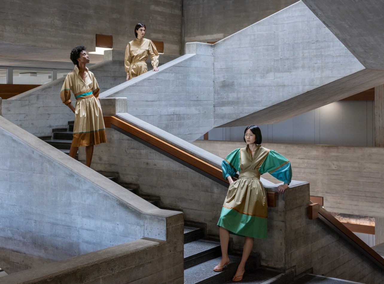 Models along a staircase wearing archival Akris dresses