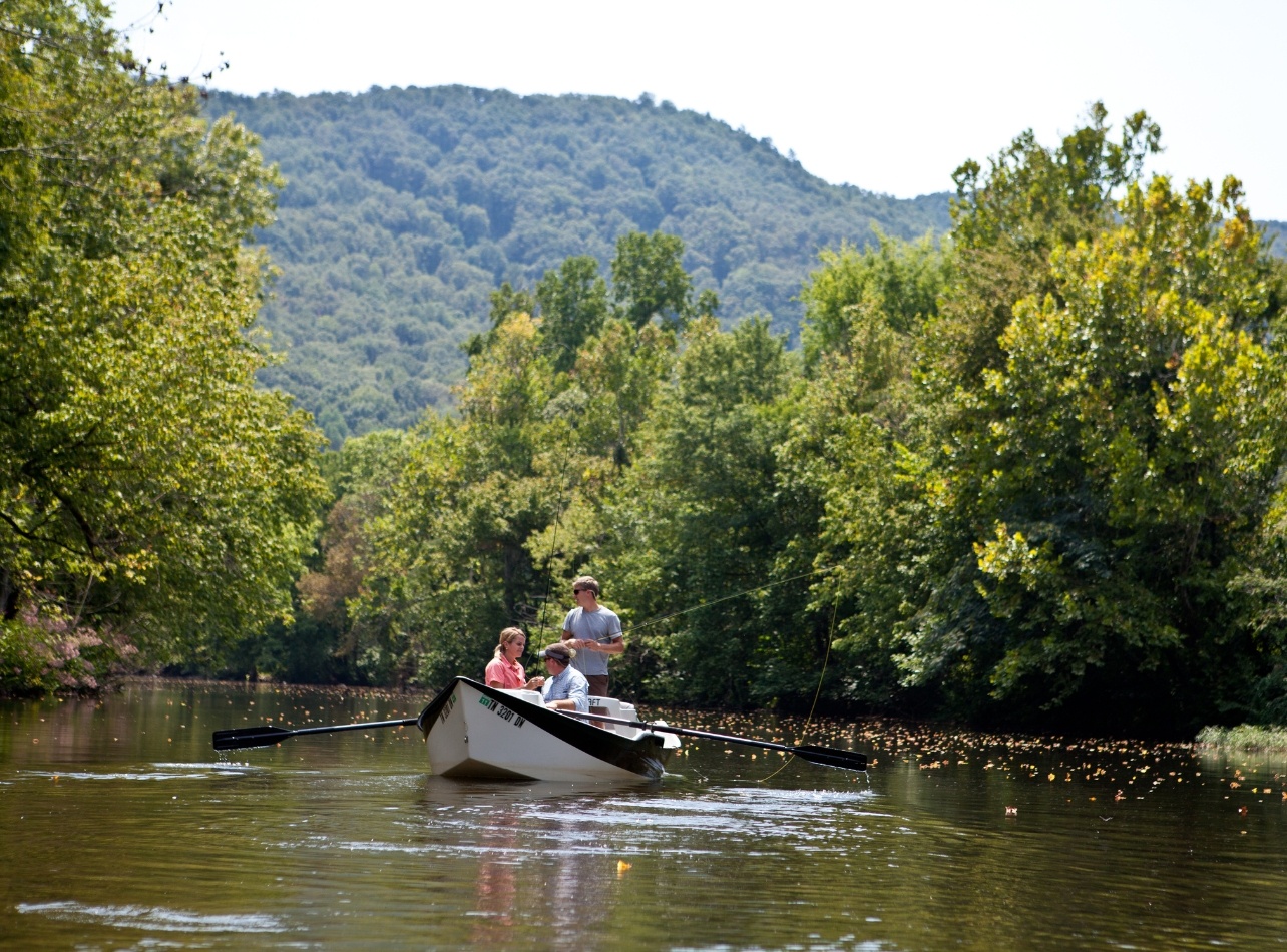 View guests on a boat fly fishing in the stream at Blackberry farm