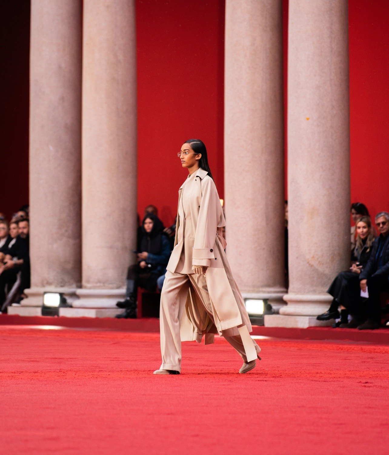 Model wearing nude Ferragamo long trench coat and pants, walking in the Spring/Summer 2023 show