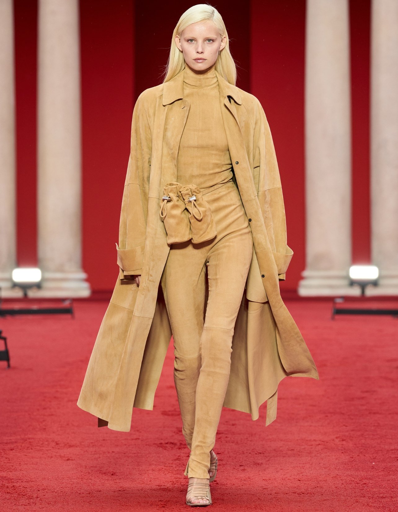 Model wearing tan monochrome suede Ferragamo trench coat, belt bag, and fitted pants, walking in the Spring/Summer 2023 show