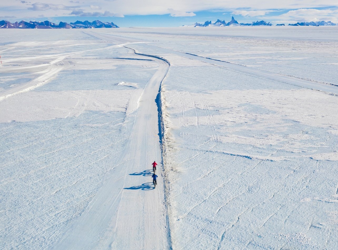 Guests biking down an icy pack to view the Ulvetanna Peak, Antarctica