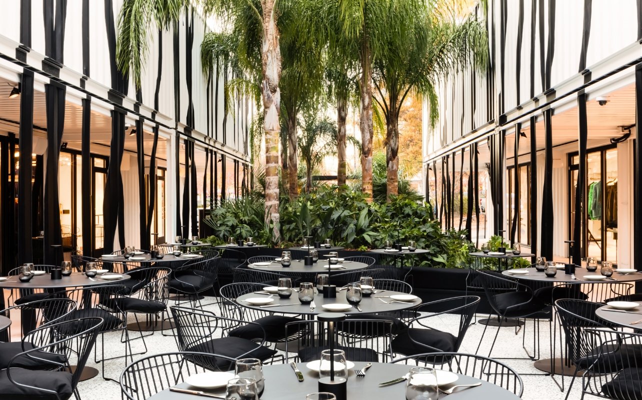 Center courtyard with black tables and chairs at The Bal Harbour Shops Access Pop-up