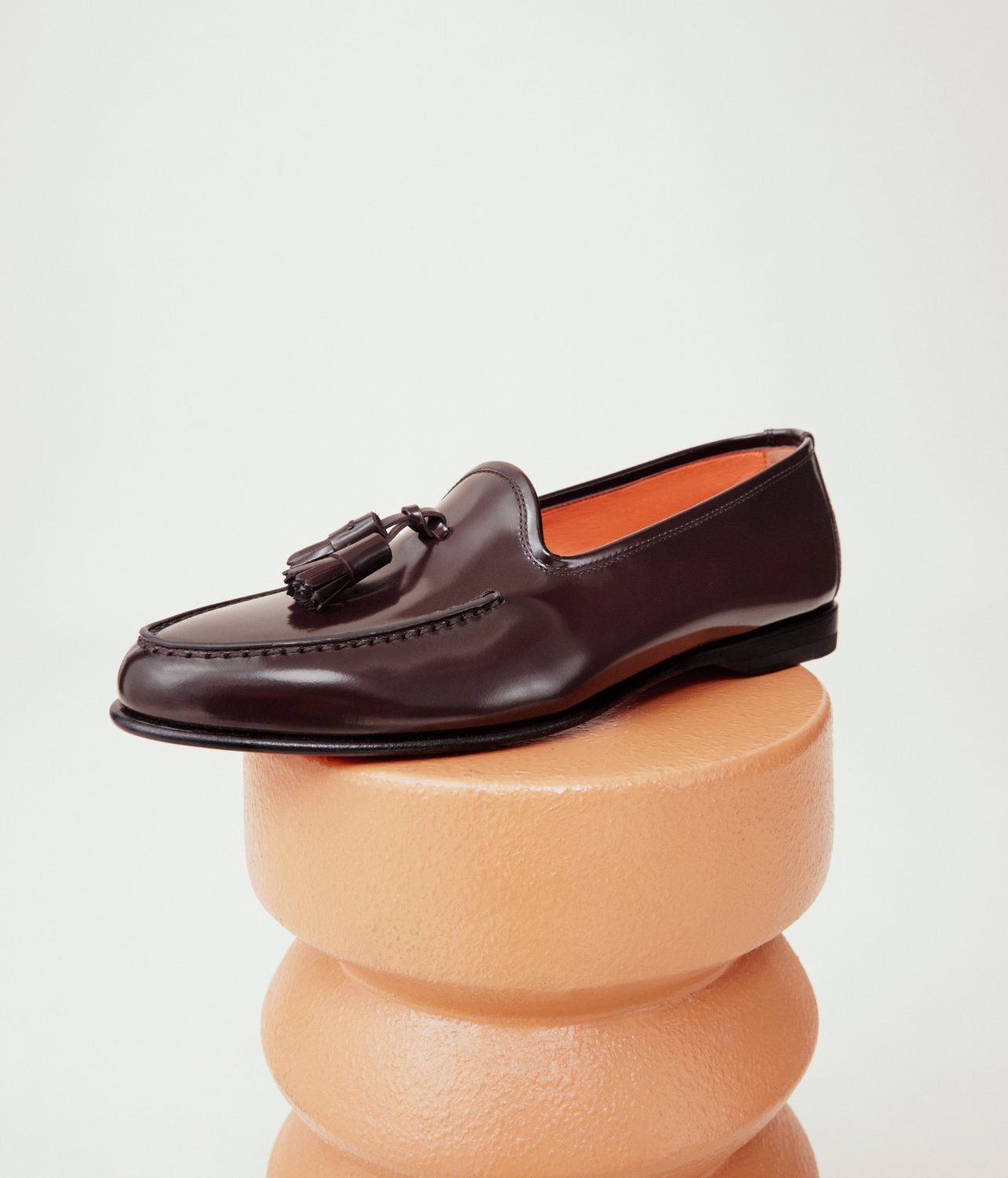 Model for Santoni modeling the new Andrea loafer in orange with gold hardware