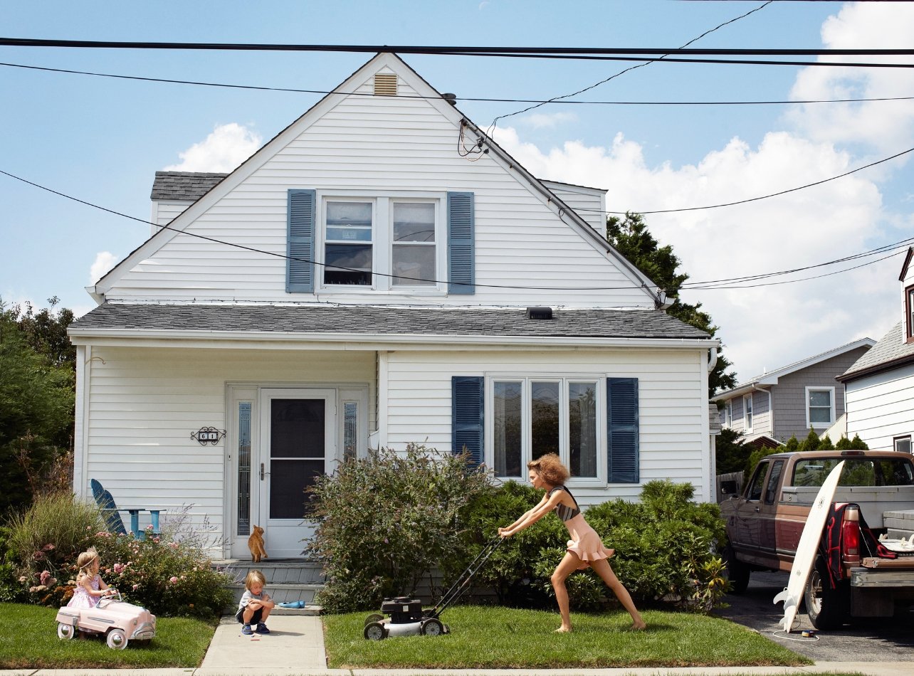 Portrait of Karlie Kloss posed mowing a lawn in Atlantic Beach, NY for Vogue 2012