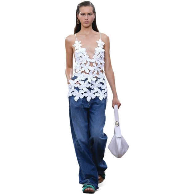 Model wearing crochet floral top with denim and white leather bag