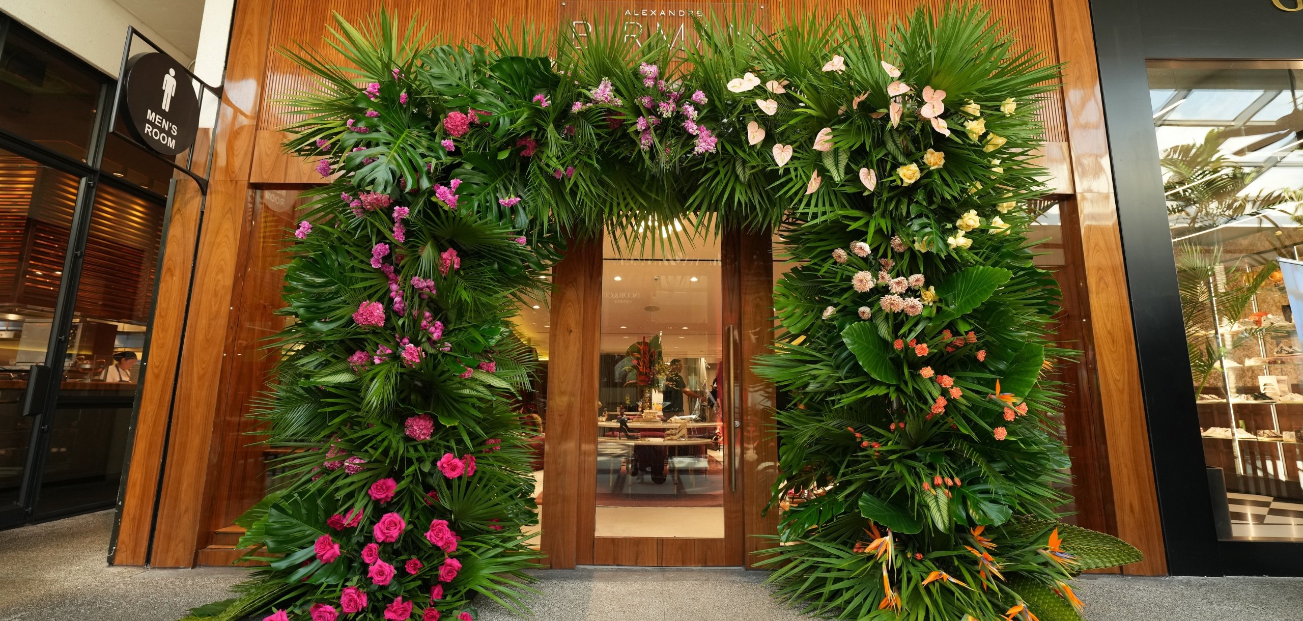 Entrance of the Alexandre Birman boutique adorned with a floral arch