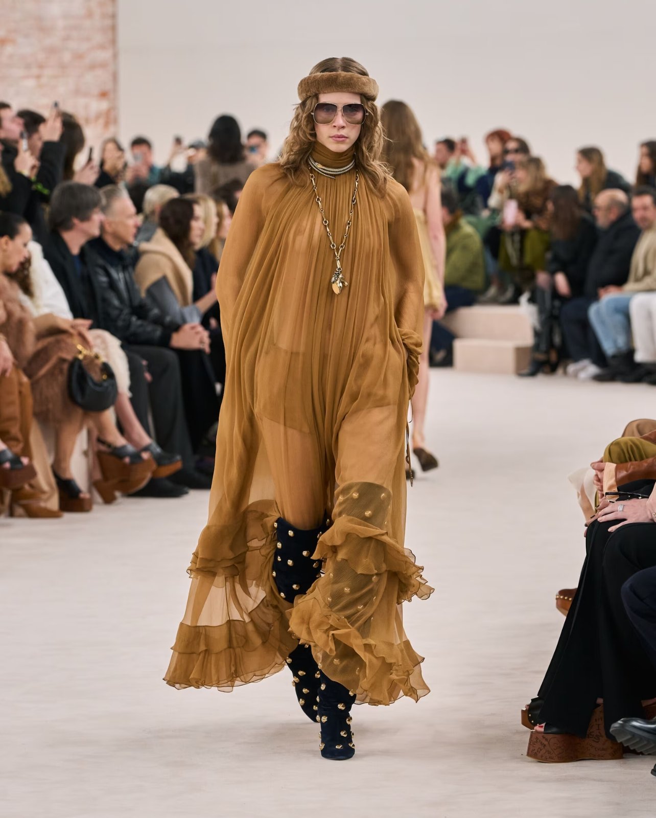 A look from Chloe’s fall/winter fashion show featuring a sheer maxi dress with suede thigh high boots