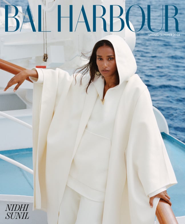 Model posing on a boat wearing an all-white Valentino look