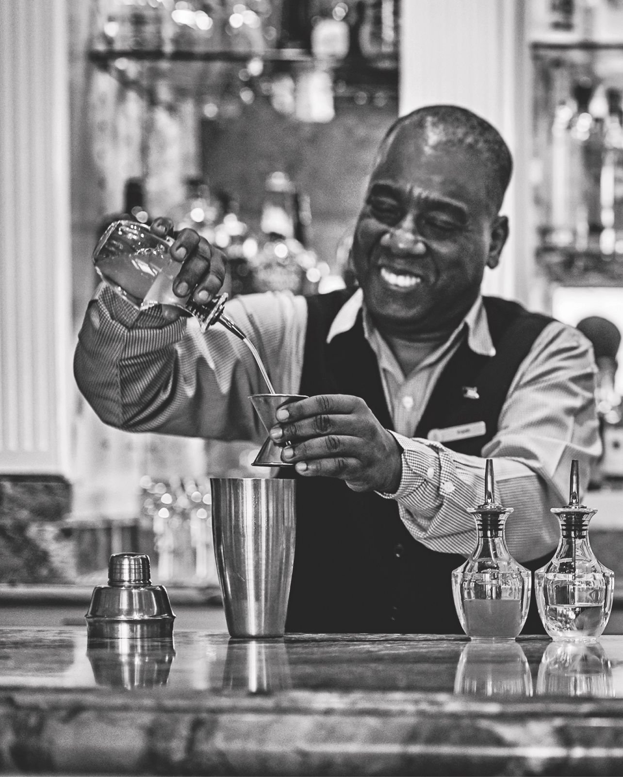 The Bartender pouring liquor behind The Ocean Club Bar