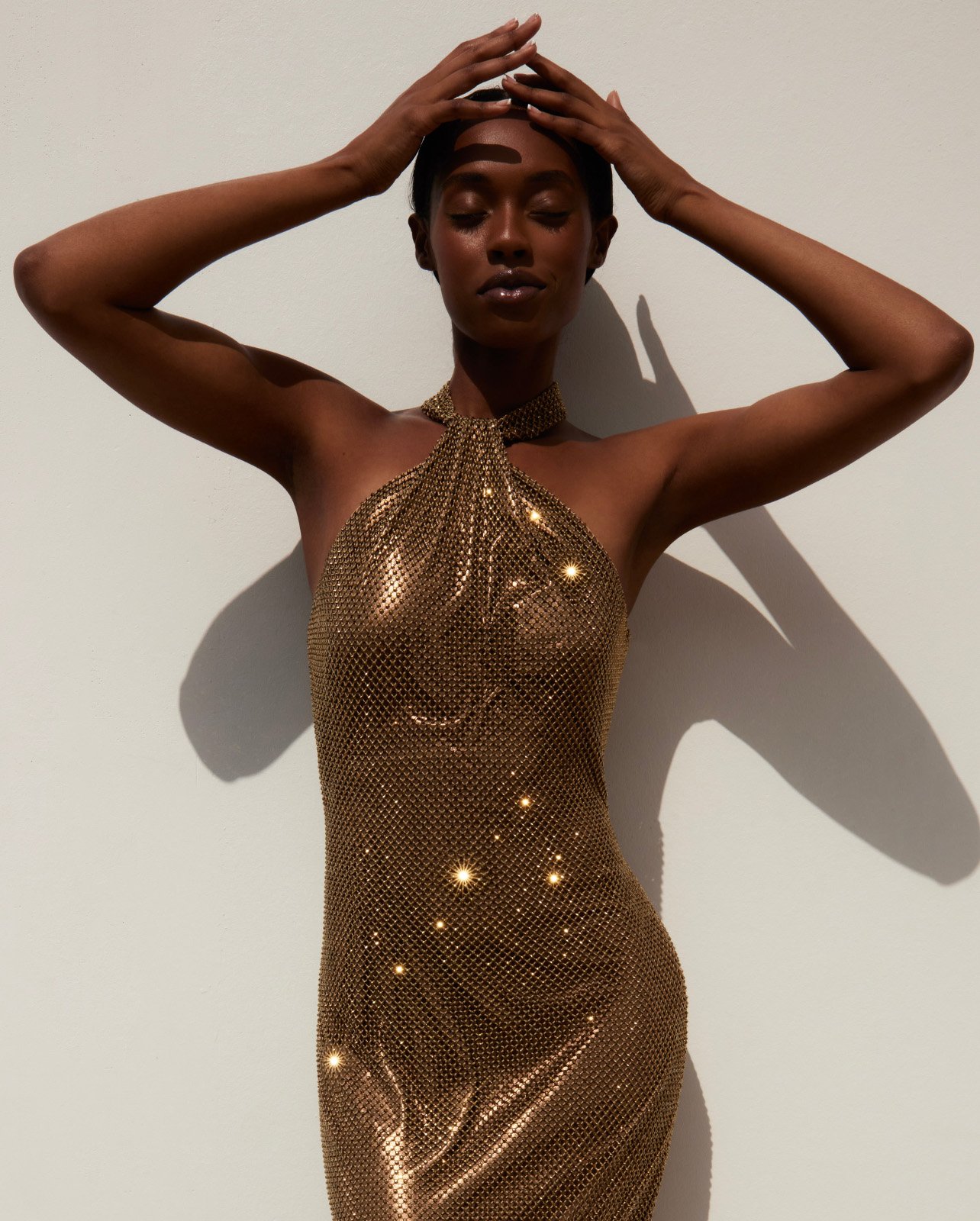 Model wearing Ralph Lauren gold halter-neck gown