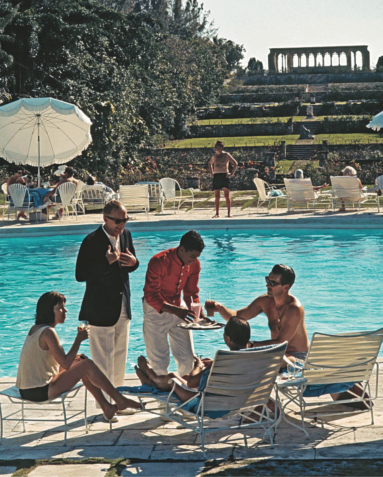 Slim Aarons photograph of guests lounging by the pool at The Ocean Club’s Versailles Gardens in 1968