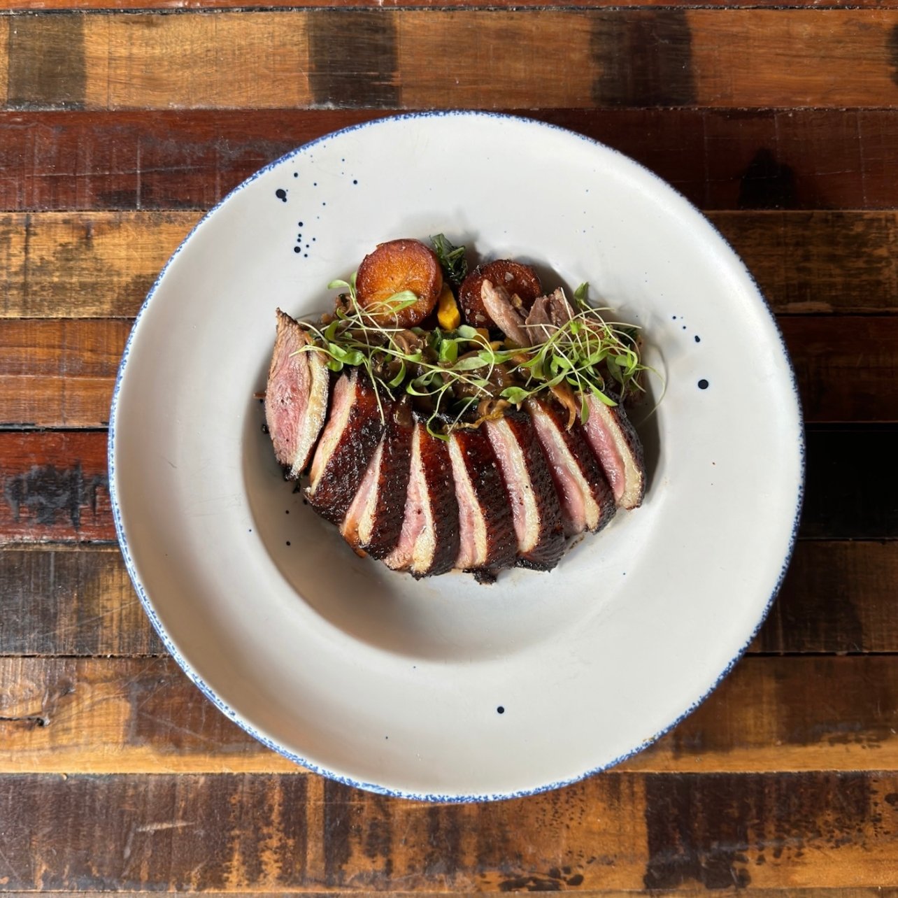 A plate of soy marinated duck and veggies at Herd Provisions
