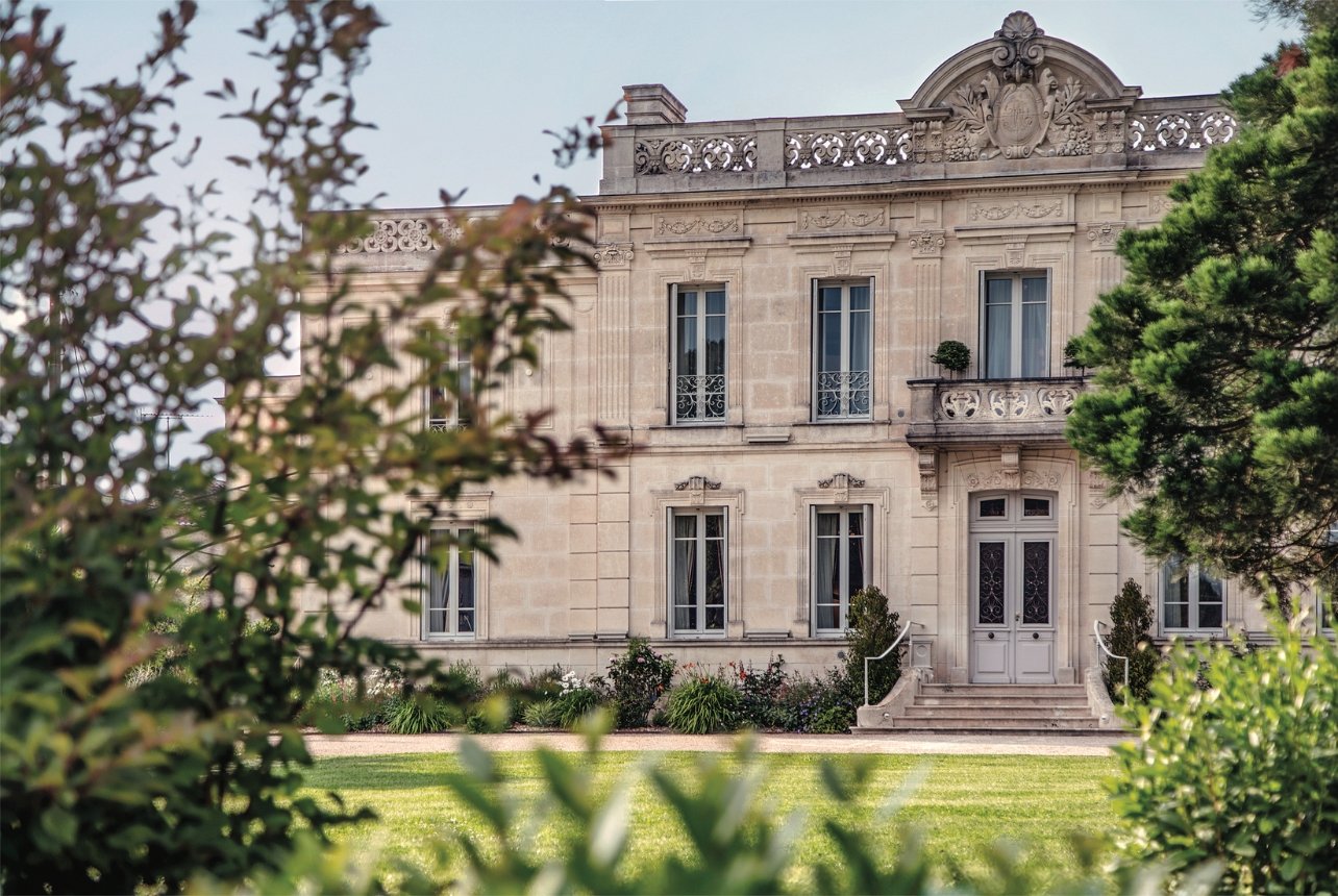 Exterior view of La Nauve Hôtel & Jardin, nestled among trees and lush gardens