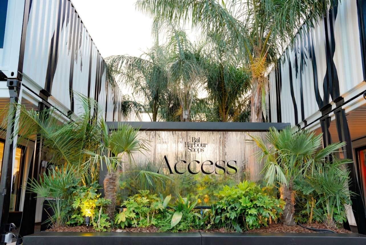 A fountain surrounded by palm trees in a courtyard for The Bal Harbour Shops Access pop-up event