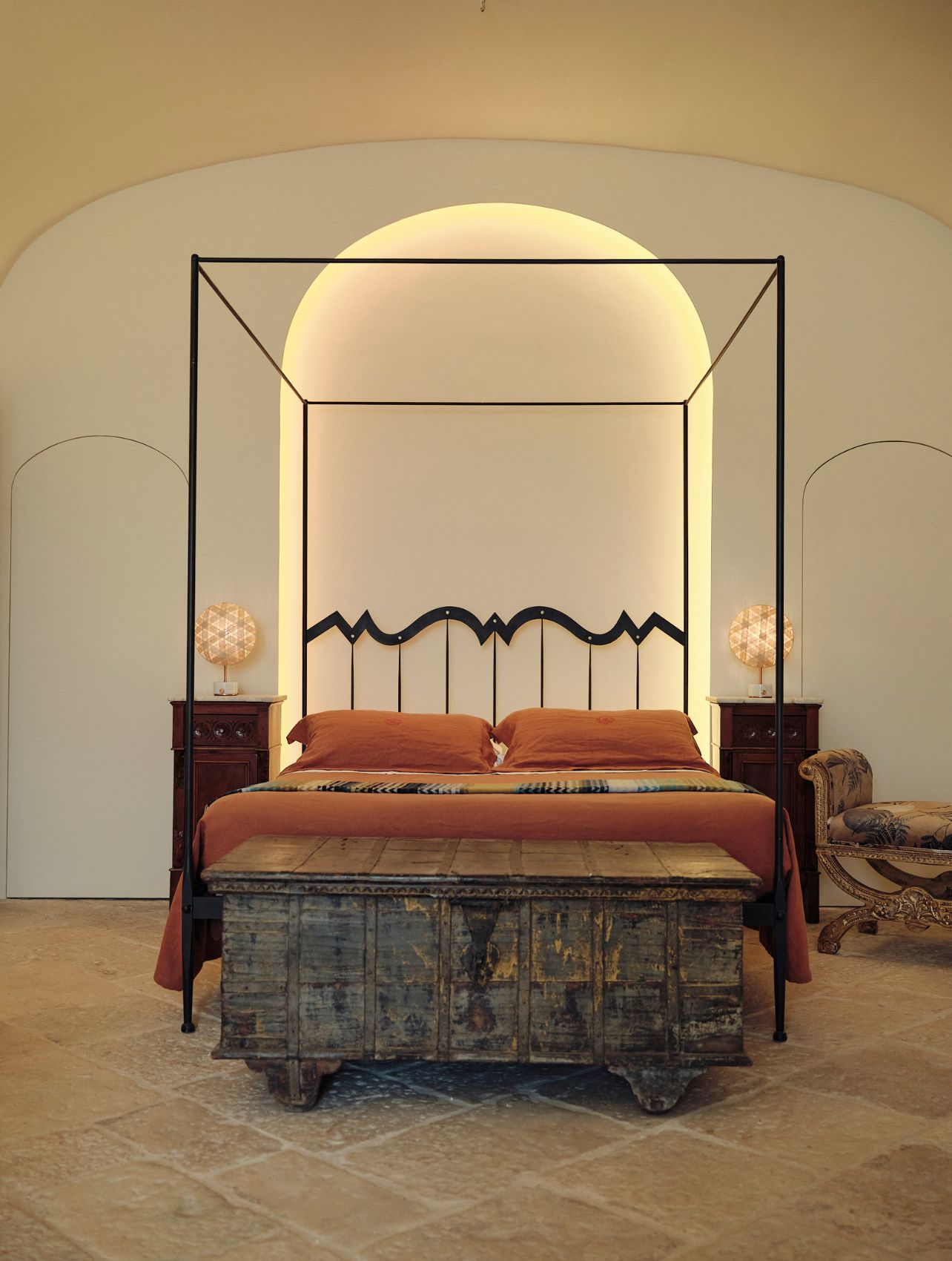 Interior shot of a bedroom with orange bedding