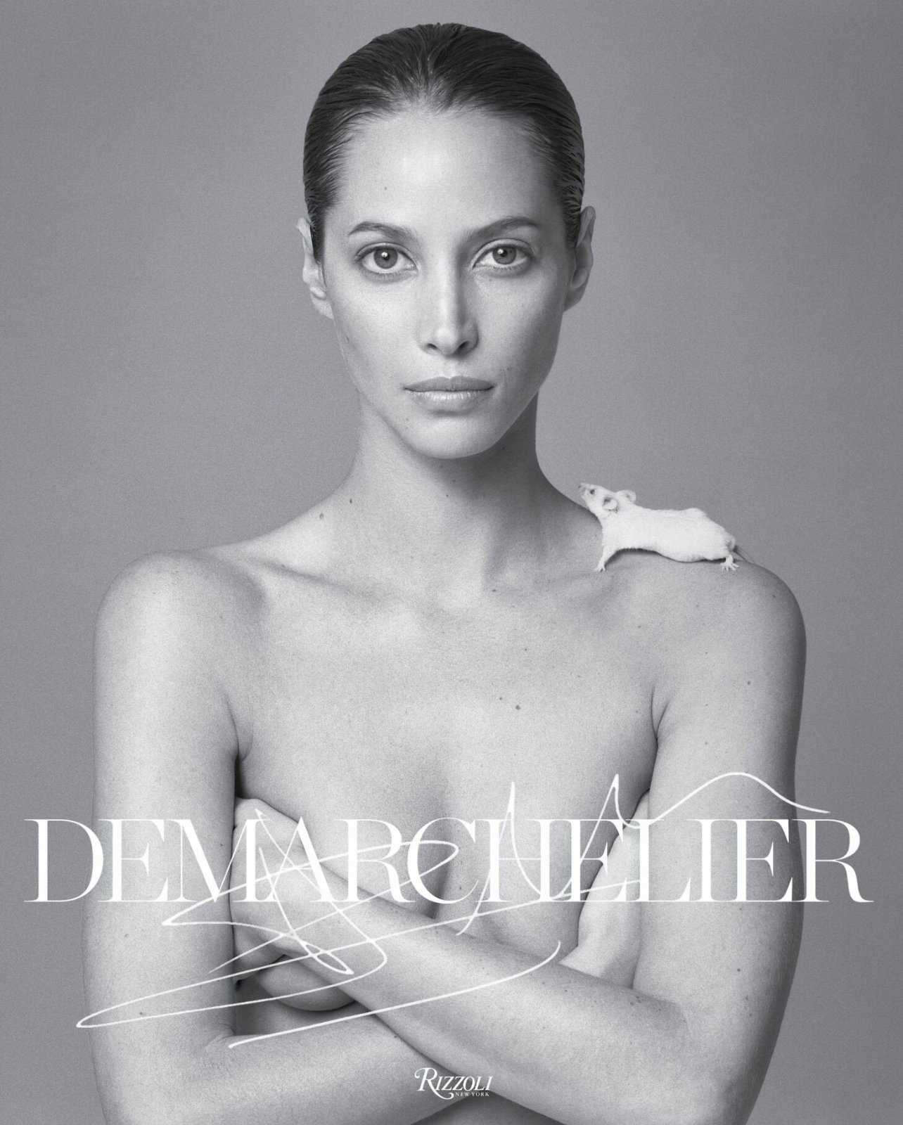 A black and white photo of fashion model, Christy Turlington posing nude with a large white rose on her head