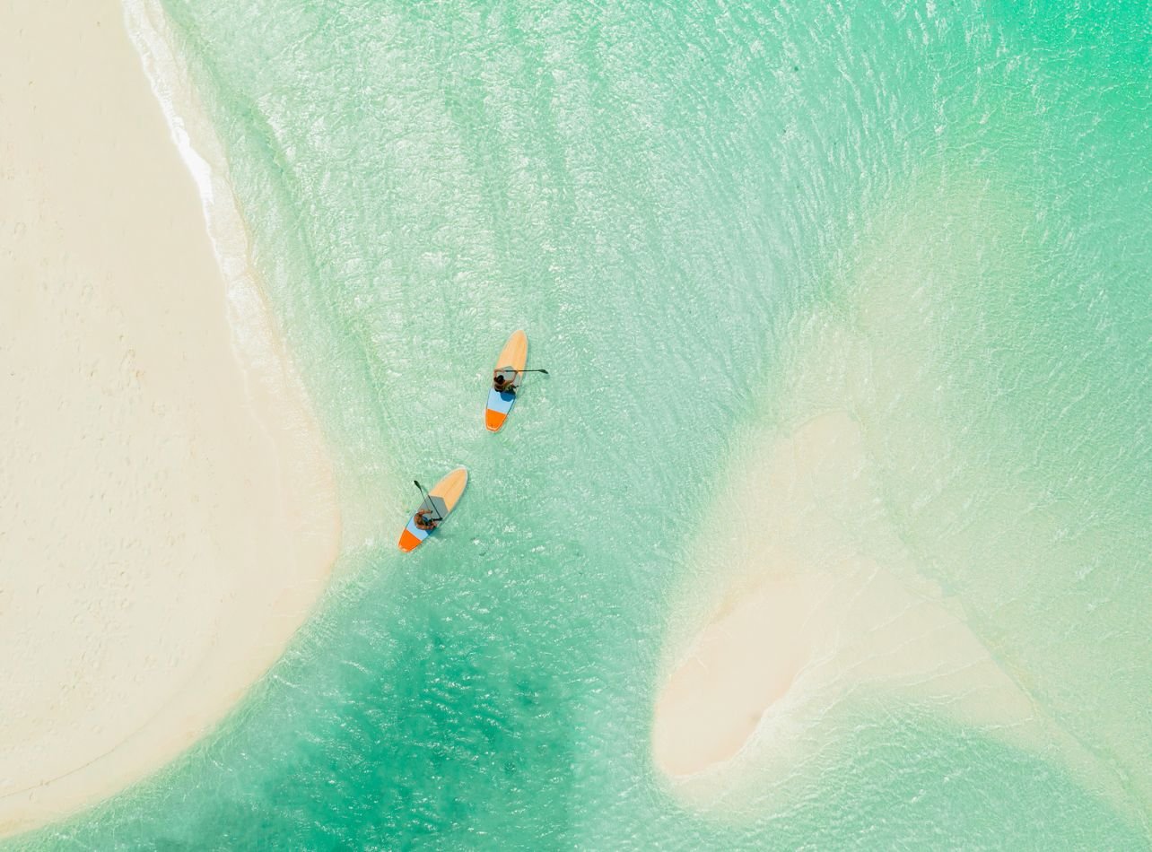 Aerial view of two people kayaking in the middle of ocean