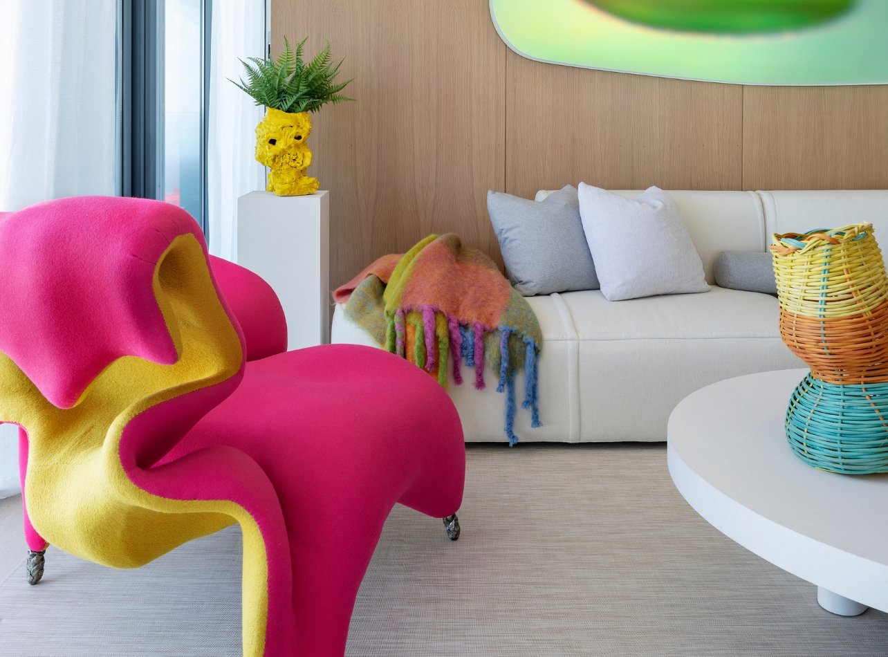 Lee Mindel’s condo at Eighty Seven Park, featuring colorful artwork and a lively mix of colors and textures, with a bioluminescent sculpture above the couch