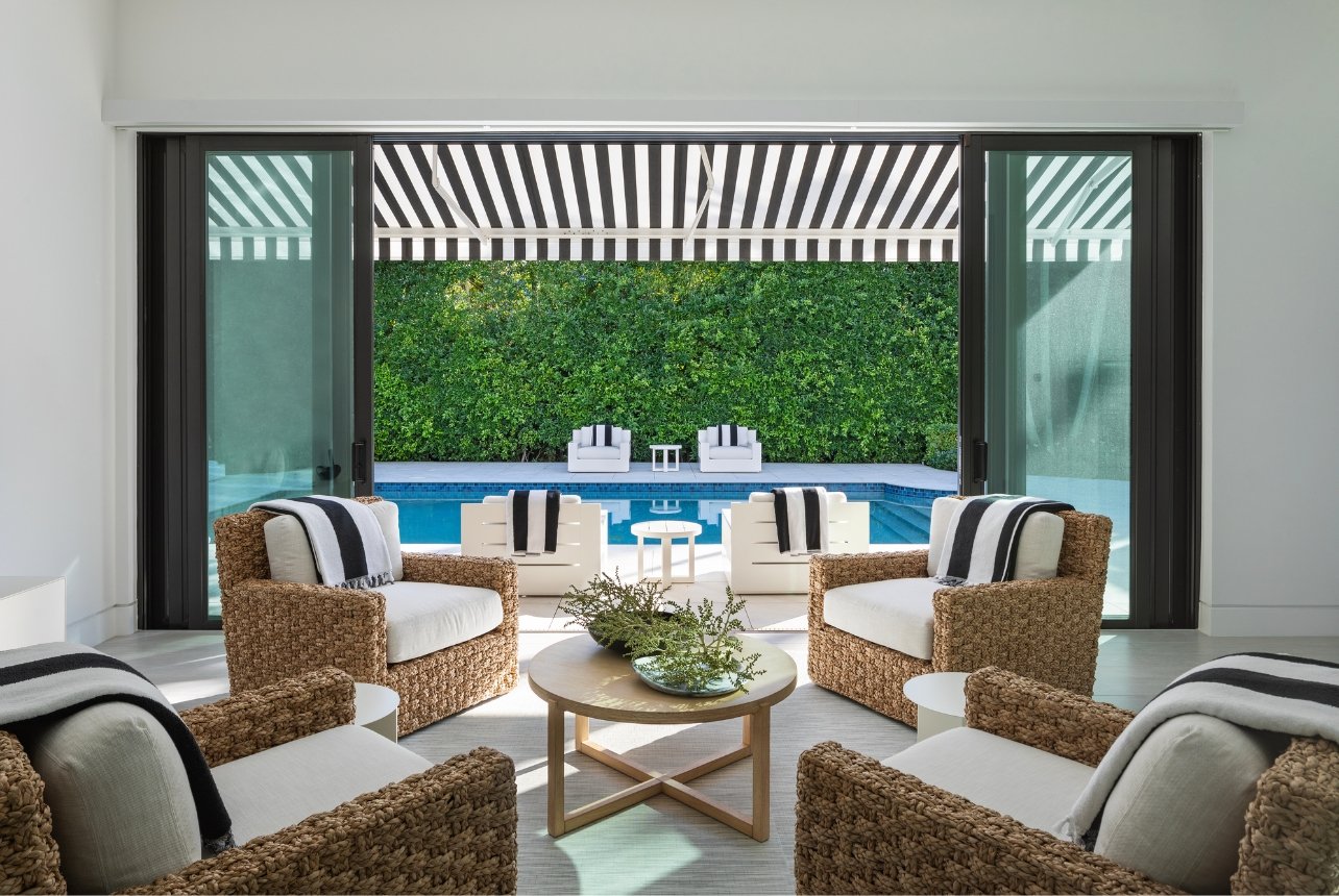 A sunny seating area with Costa lounge chairs, opening onto the pool patio