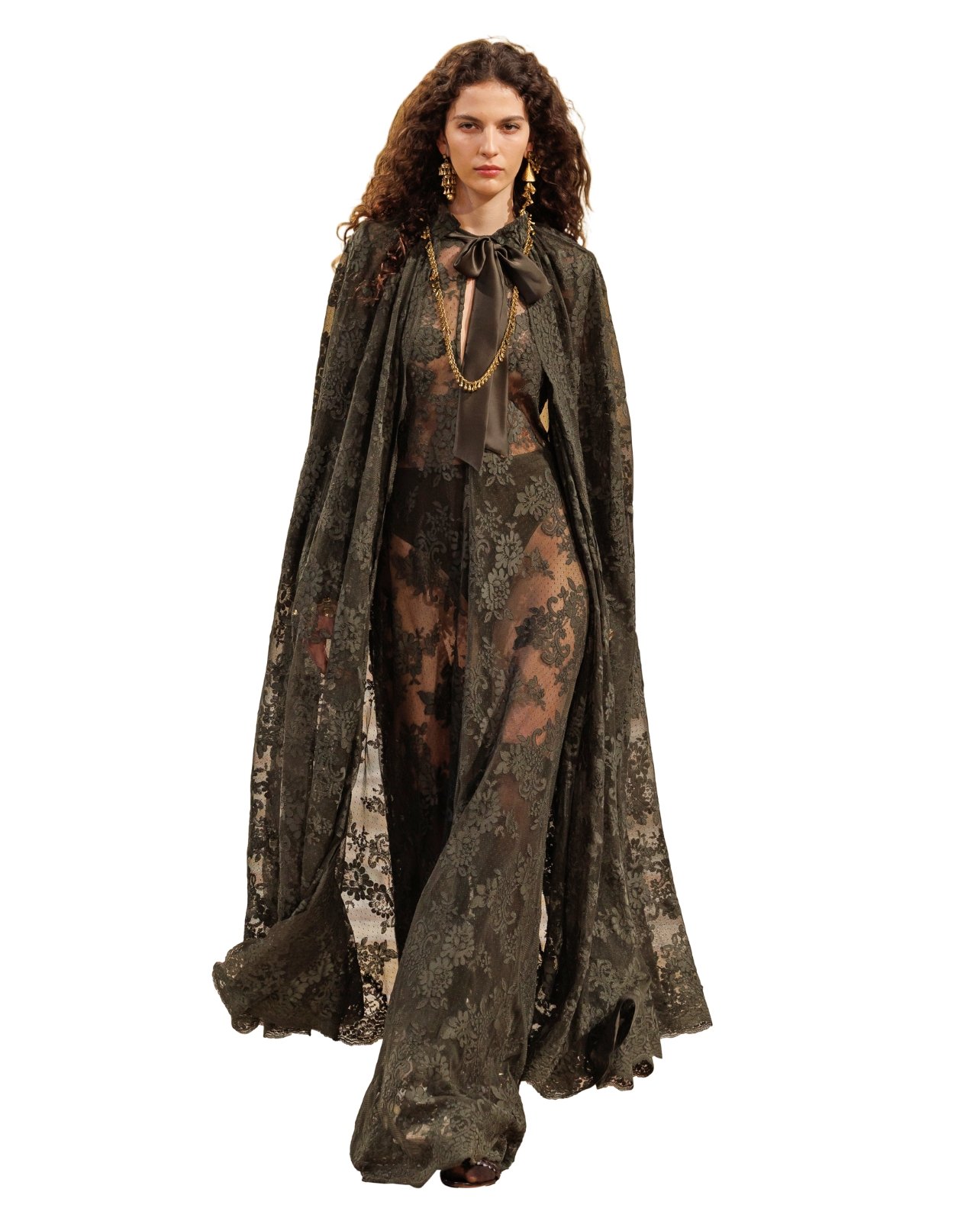 Runway model wearing a black lace maxi dress and matching floor length lace cape