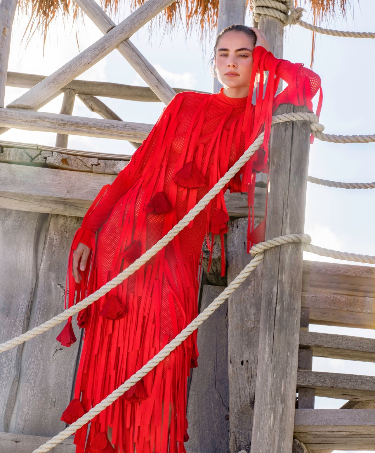 Fashion model wearing a long red fringe dress
