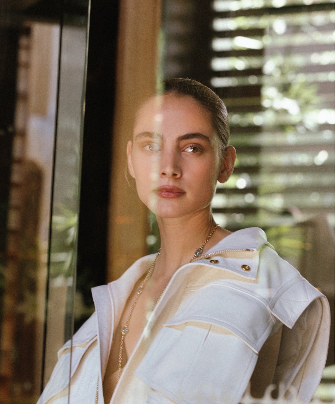 Fashion portrait of a model looking through a window