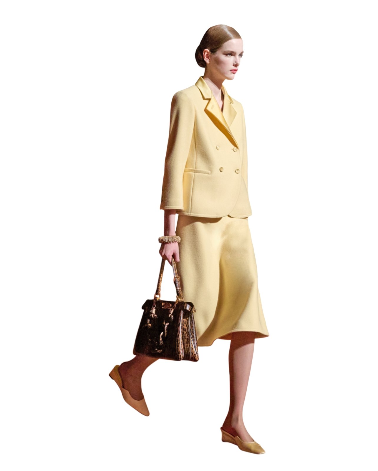 Runway model in a butter yellow matching suit and skirt, styled with a leopard purse