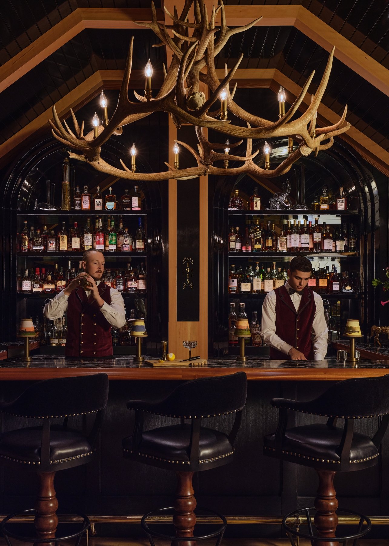Two men making drinks at the bar at Auric Room 1915 in Big Sky, Montana