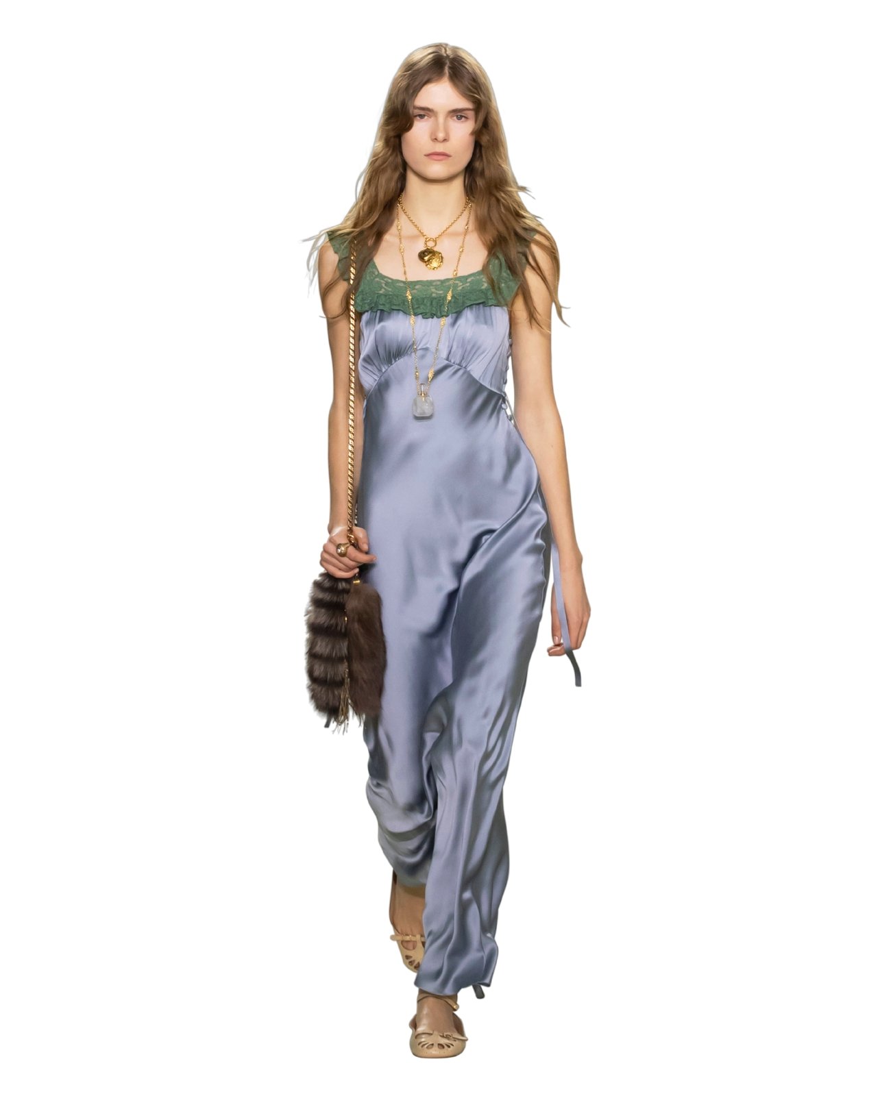 Runway model wearing a silk blue maxi dress and fur accessories