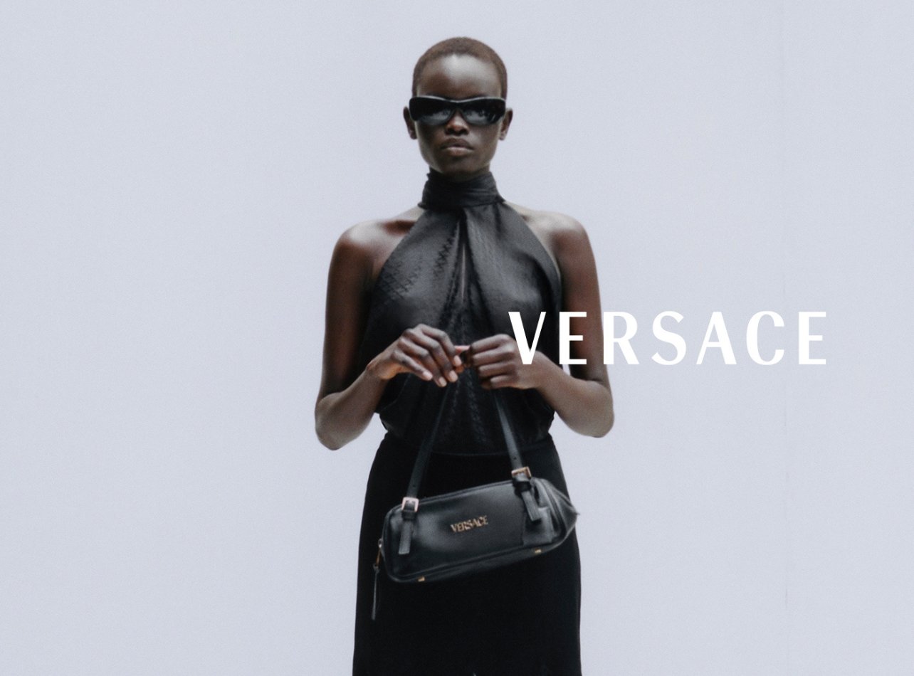 Model in black Versace look with black sunglasses and black bag