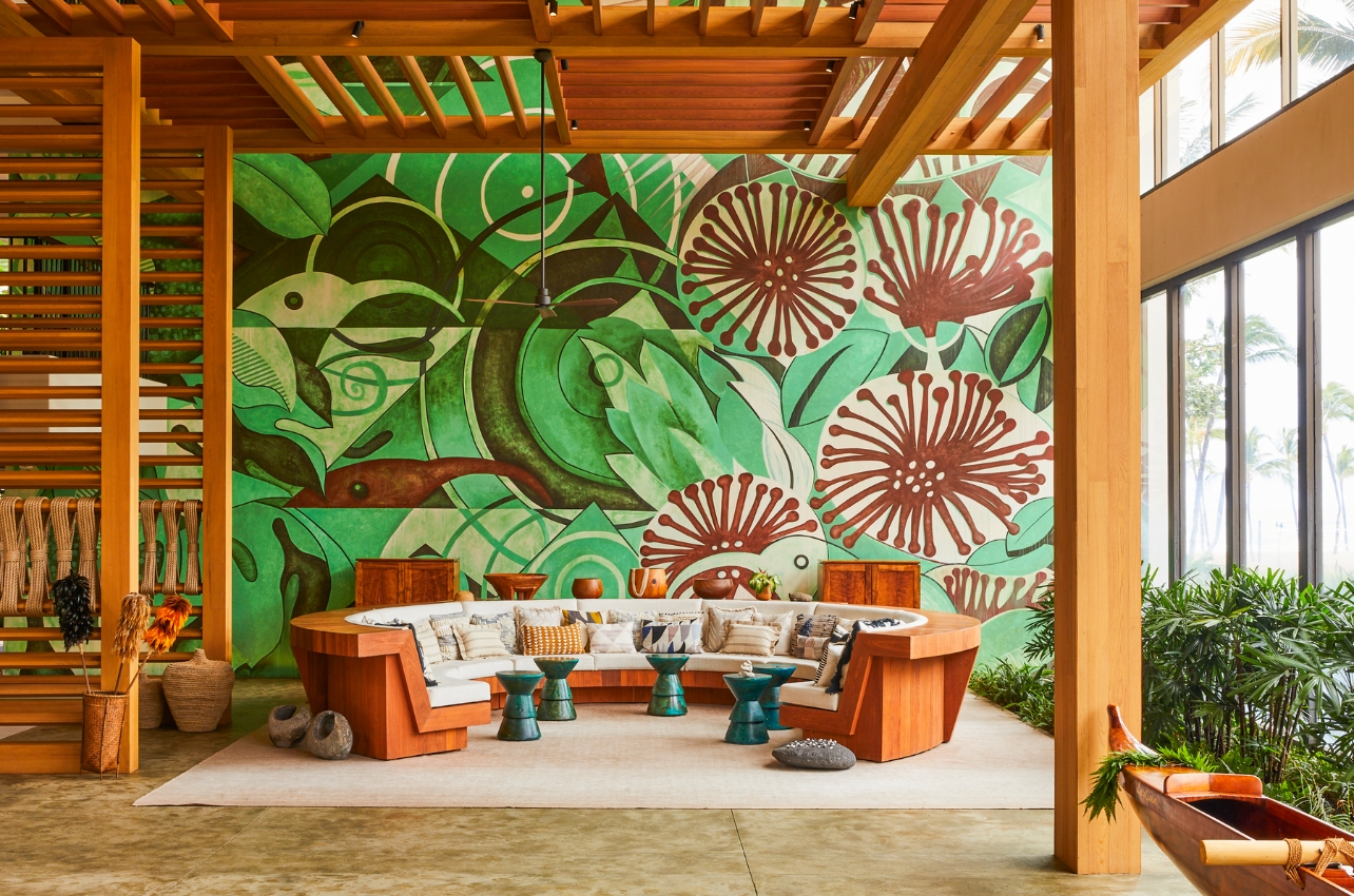 Interior space with a circular couch seating area and a botanical mural on the wall