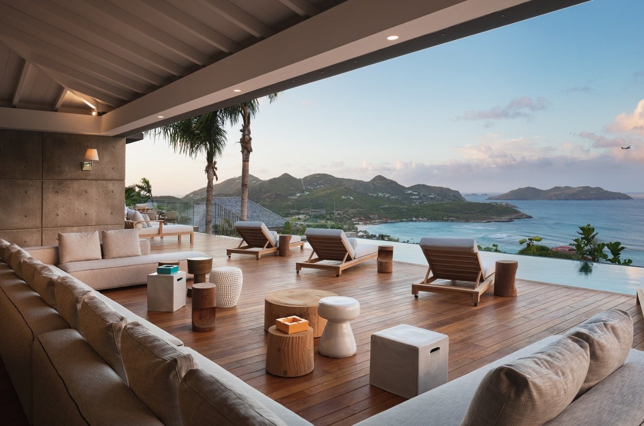 A villa with seating and view of St Barths water and sunset