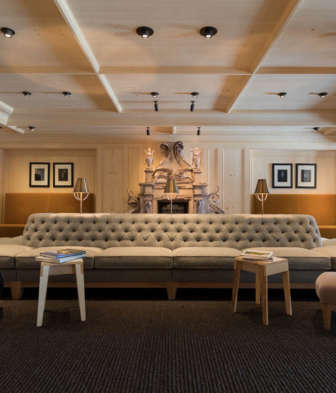 Interior of a hotel seating area with a long couch and coffee tables