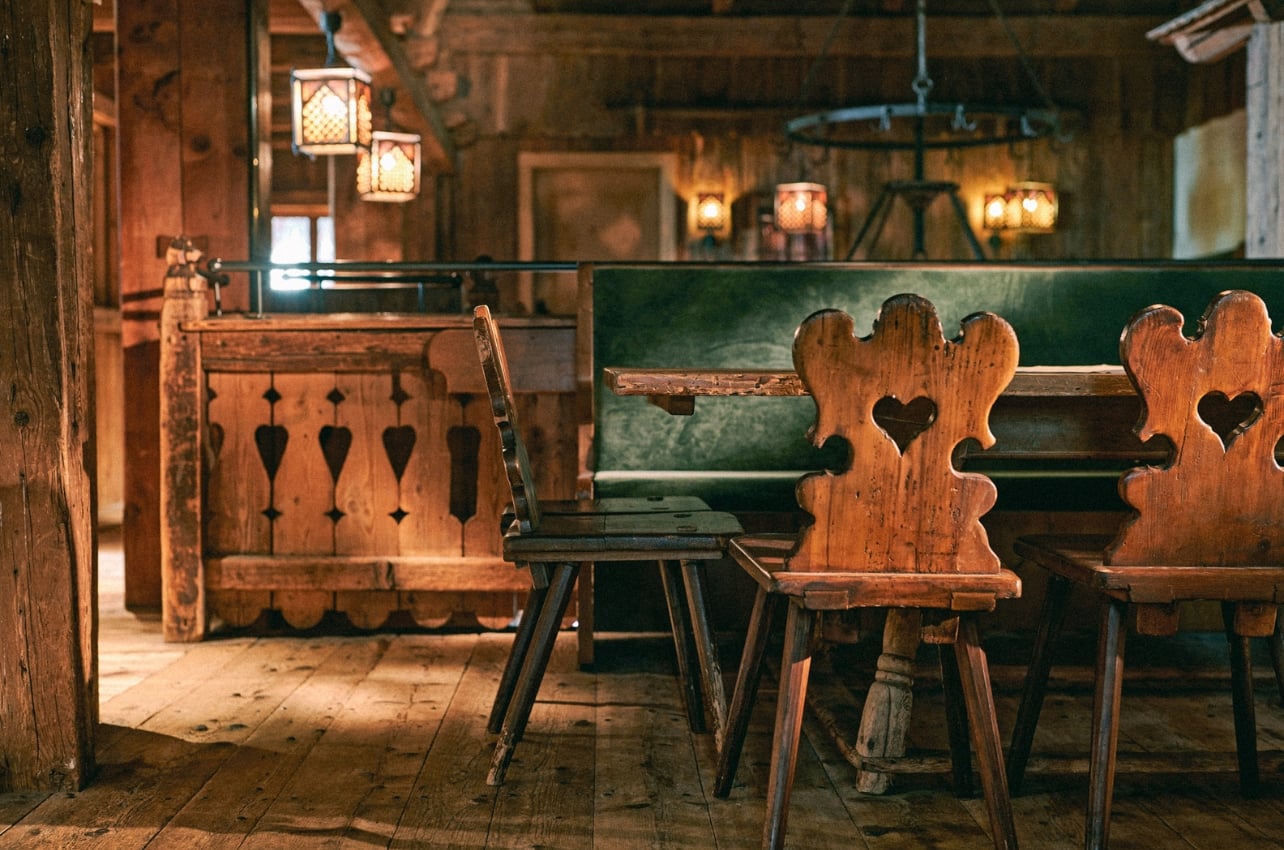 A dining room with cozy dark wood features and dim lighting