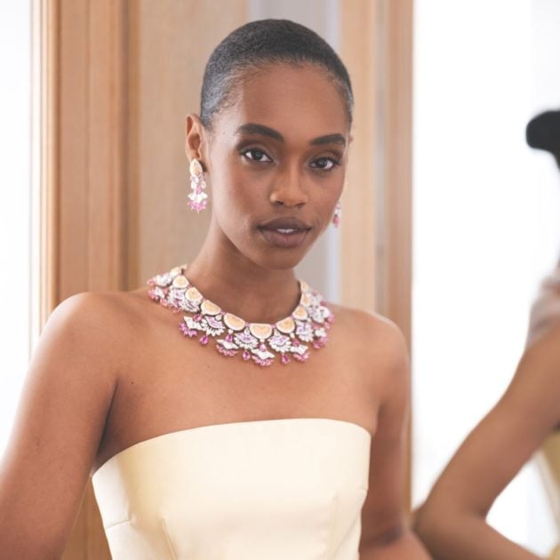 Model wearing a large diamond necklace and earrings with a strapless dress