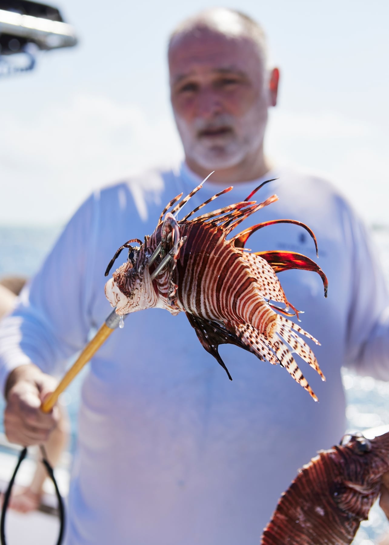 Portrait of a man holding a fish on a spear