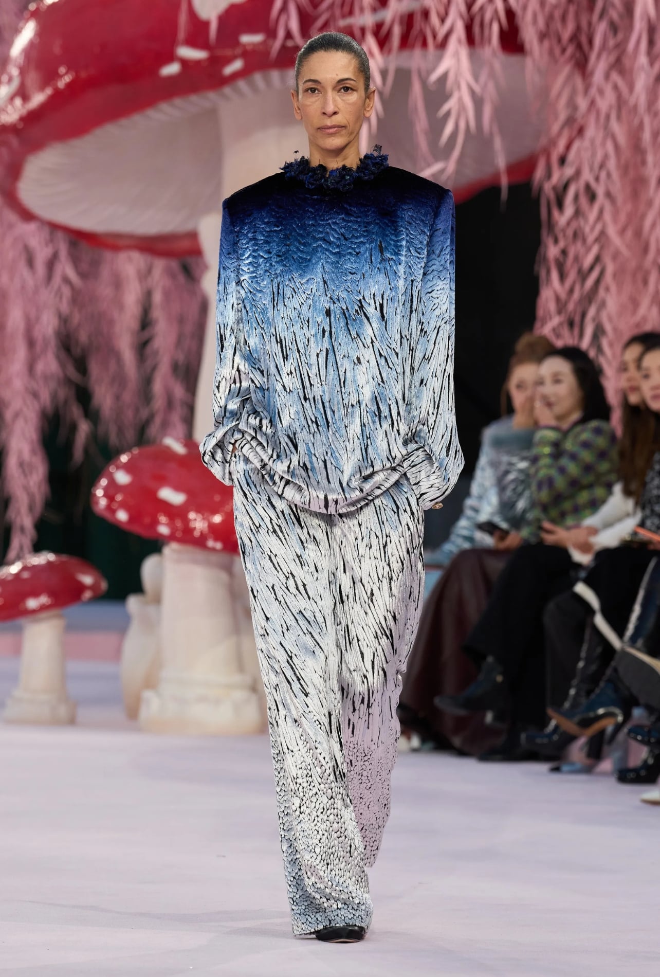 Chanel runway model wearing a matching top and pant set with a blue and white pattern