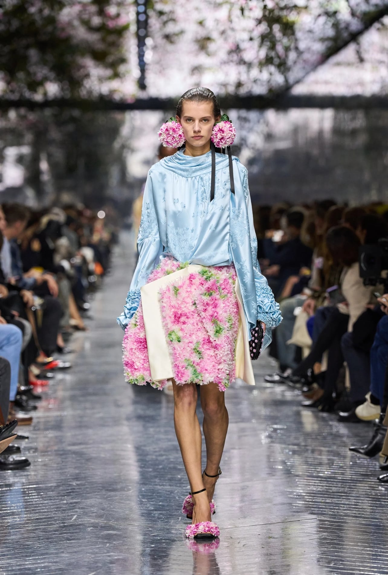 Christian Dior runway model wearing earrings and a skirt made of flowers